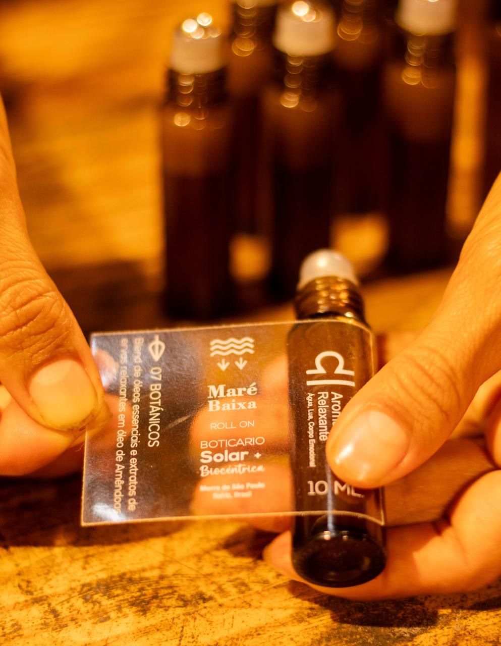 Etiqueta de la línea Boticario Solar junto al roll-on de aceites, en la mesa de trabajo