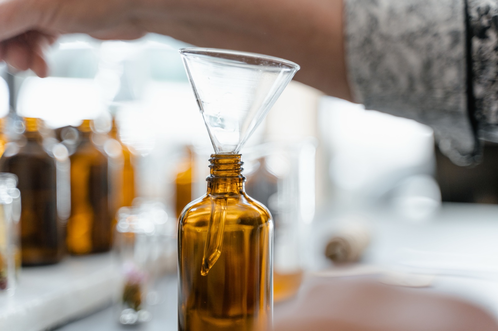 Trasvasando aceite con un embudo de vidrio a un frasco ámbar, en el laboratorio