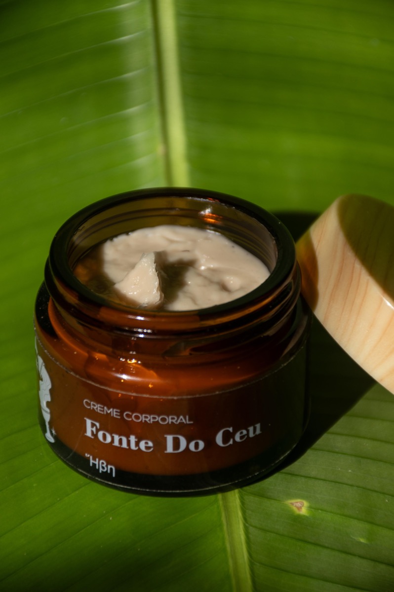 Crema corporal natural abierta sobre una hoja de banano