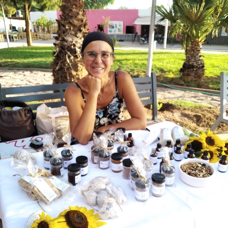Cintia en su puesto de feria, con los productos de Killa y Abaukan sobre la mesa